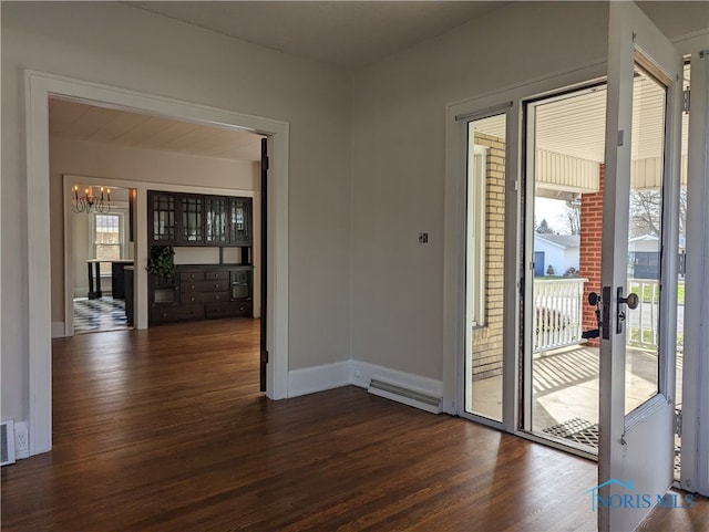 doorway featuring a wealth of natural light, dark hardwood / wood-style floors, and a chandelier