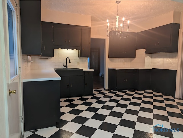 kitchen with dark brown cabinets, a chandelier, tasteful backsplash, and light tile patterned floors