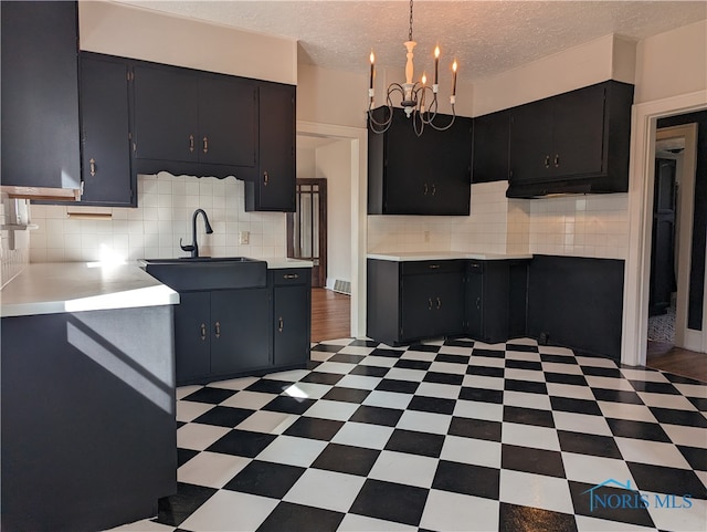 kitchen with dark tile patterned floors, backsplash, and sink