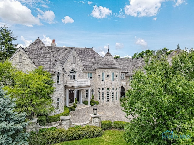 back of property featuring a balcony and a patio