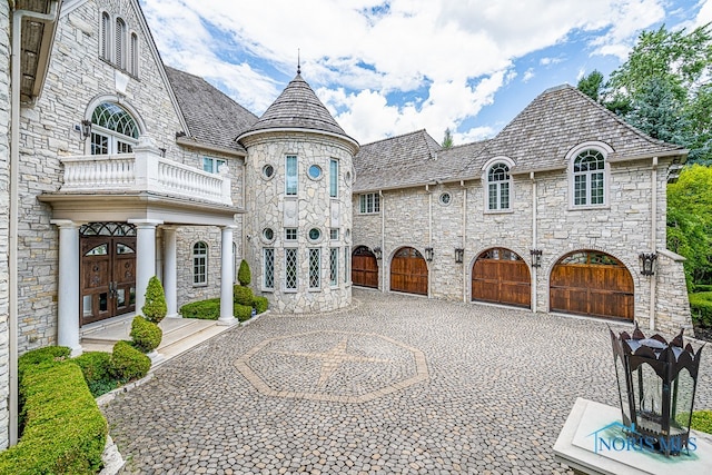 french provincial home featuring a balcony, french doors, and a garage