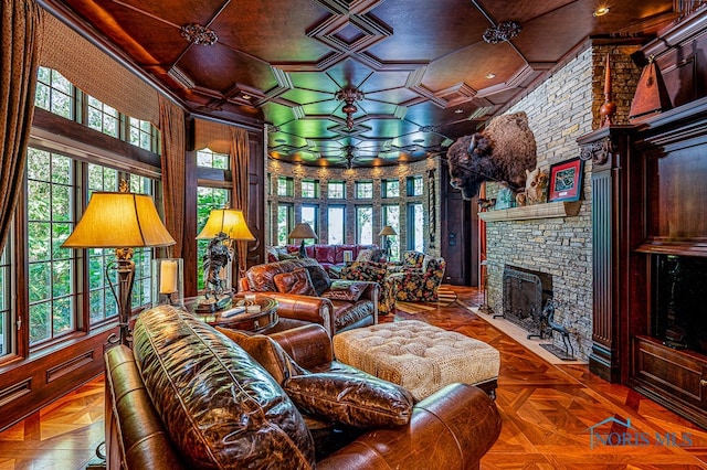 living room with parquet flooring, a stone fireplace, and crown molding