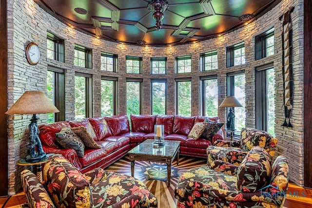 living room with a towering ceiling and wood-type flooring