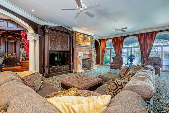 living room with ornamental molding, a premium fireplace, ceiling fan, and decorative columns