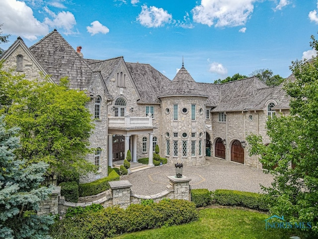 rear view of property with a balcony and a patio area