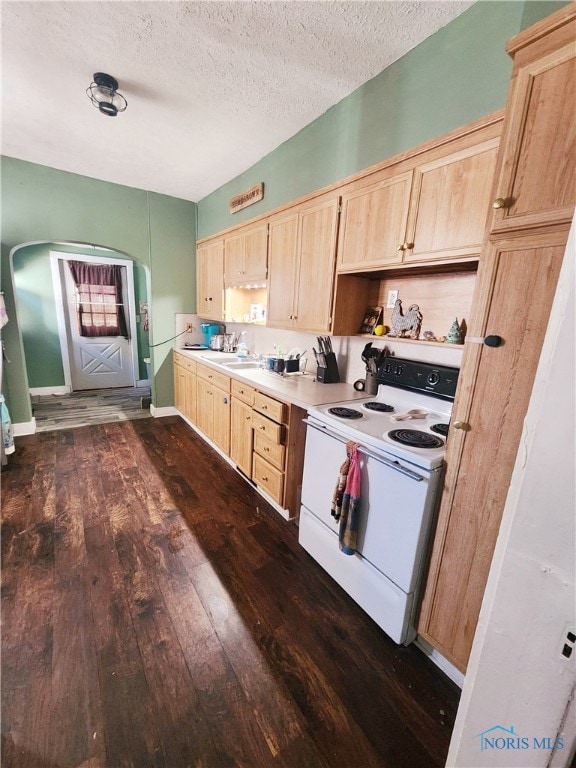 kitchen with light brown cabinetry, a textured ceiling, white electric stove, and dark hardwood / wood-style floors