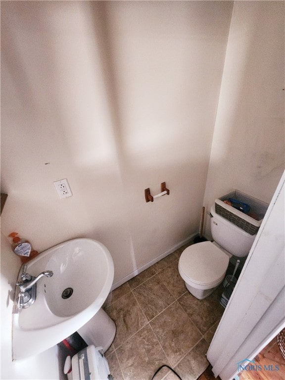 bathroom featuring sink, toilet, and tile floors