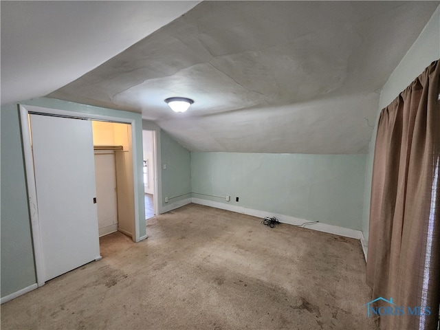 bonus room with lofted ceiling and light carpet