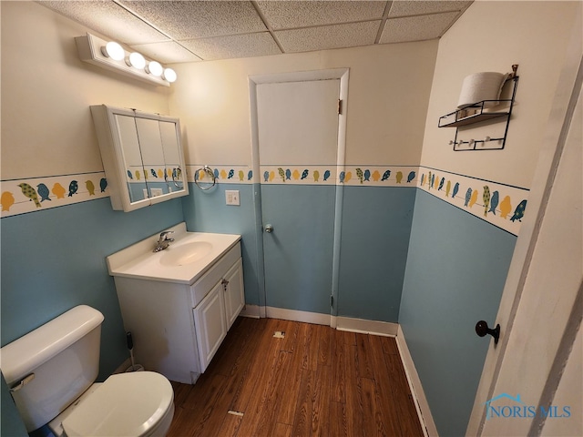 bathroom with hardwood / wood-style flooring, toilet, a paneled ceiling, and large vanity