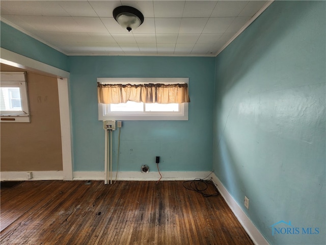 spare room with dark hardwood / wood-style flooring and crown molding