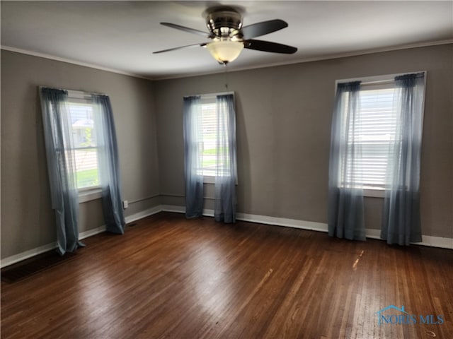 spare room with a healthy amount of sunlight, ceiling fan, and dark hardwood / wood-style flooring