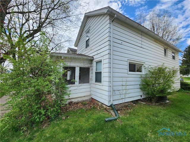 view of side of home with a yard