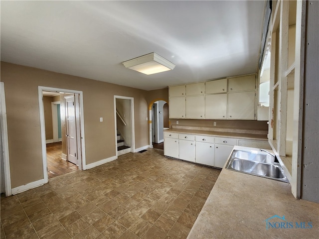 kitchen featuring white cabinets, sink, and tile flooring