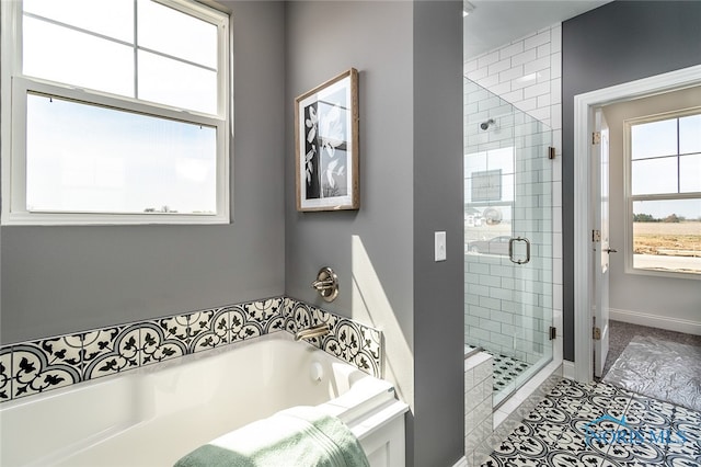 bathroom featuring tile patterned floors, a wealth of natural light, and independent shower and bath