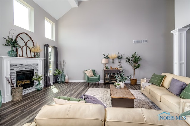 living room with a fireplace, dark hardwood / wood-style floors, high vaulted ceiling, and decorative columns