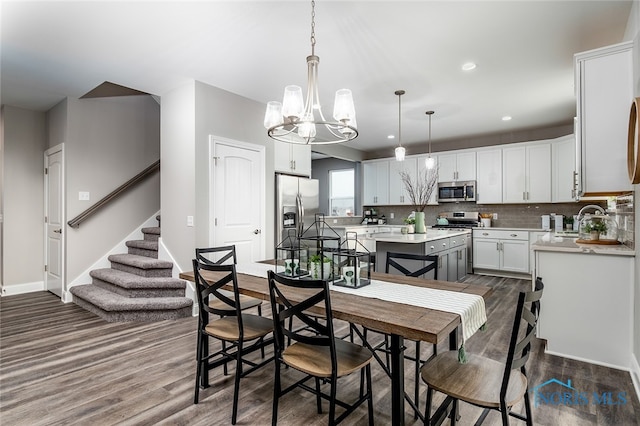 dining area featuring a notable chandelier, dark hardwood / wood-style flooring, and sink