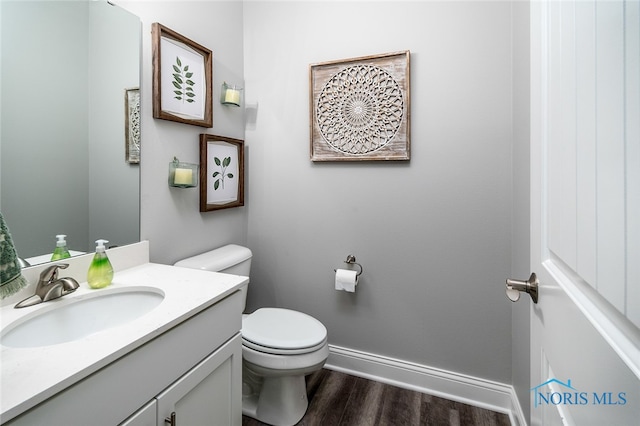 bathroom with hardwood / wood-style floors, vanity, and toilet