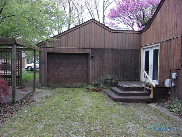 view of yard with a deck, french doors, an outdoor structure, and a garage