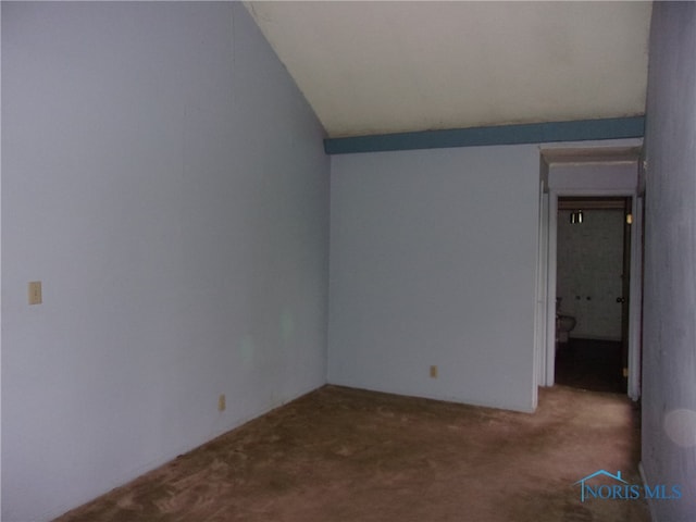 unfurnished room with vaulted ceiling and carpet flooring