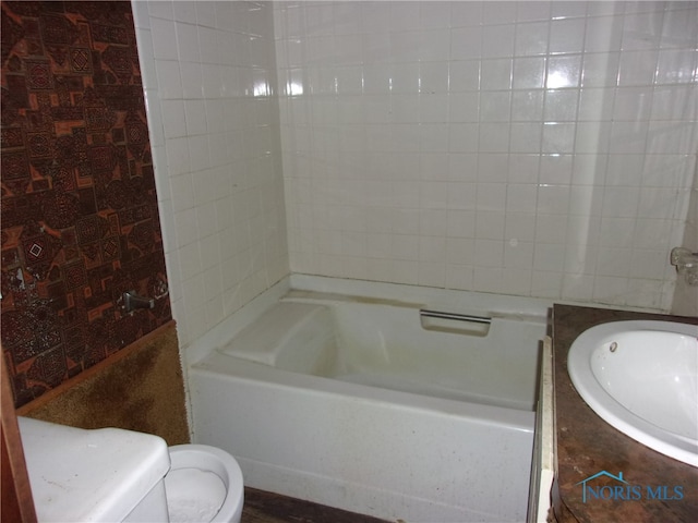 full bathroom featuring tiled shower / bath combo, toilet, and vanity