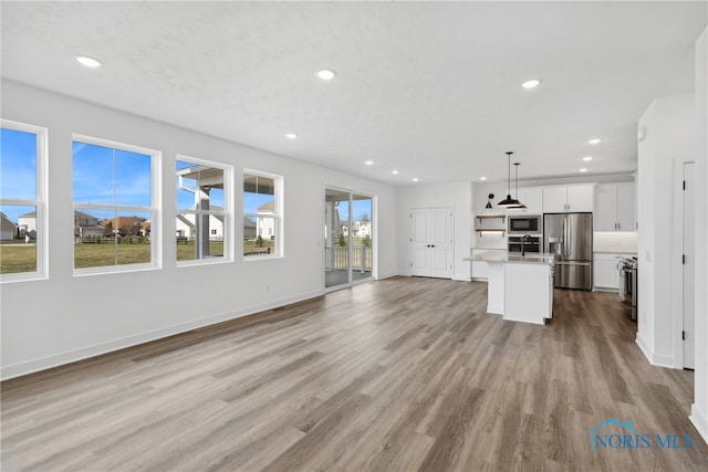 unfurnished living room with light hardwood / wood-style floors and sink