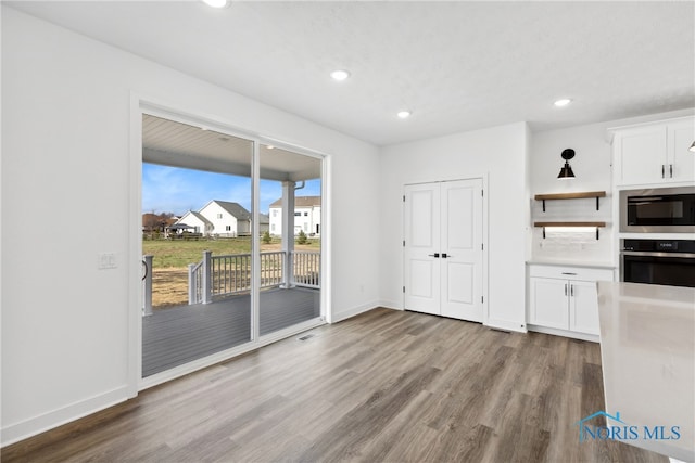 kitchen featuring white cabinetry, light hardwood / wood-style flooring, and appliances with stainless steel finishes