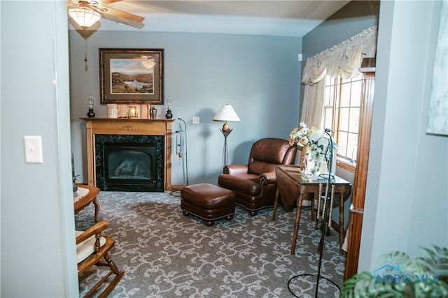 sitting room with a fireplace, carpet floors, and ceiling fan