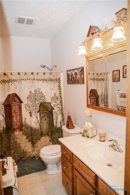 bathroom featuring vanity, toilet, and a textured ceiling