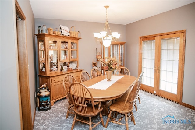 dining area with a chandelier, carpet, and french doors