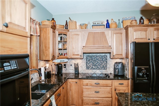 kitchen with dark stone counters, premium range hood, tasteful backsplash, and black appliances