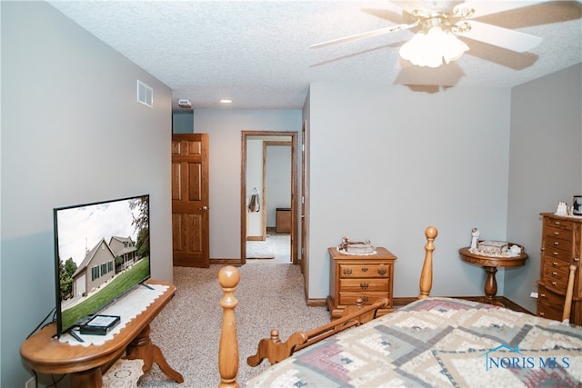 carpeted bedroom featuring a textured ceiling and ceiling fan