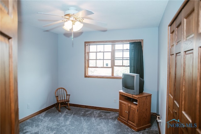 interior space featuring dark carpet and ceiling fan