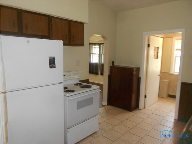 kitchen with white appliances and light tile flooring