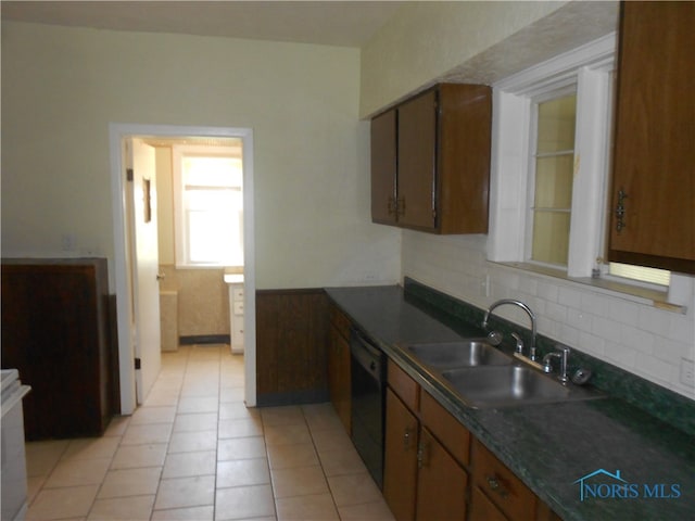 kitchen with sink, tasteful backsplash, black dishwasher, and light tile floors