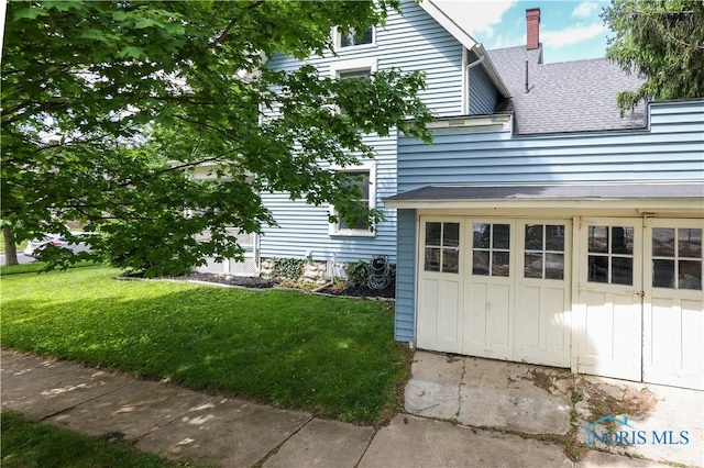 view of property exterior featuring a garage and a yard