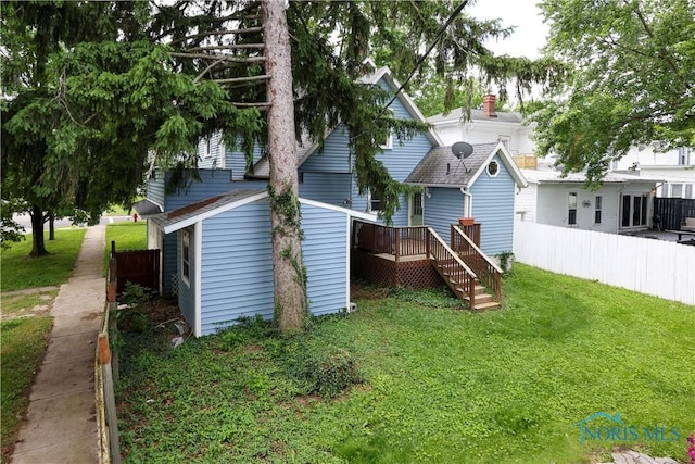 rear view of property featuring a deck and a yard