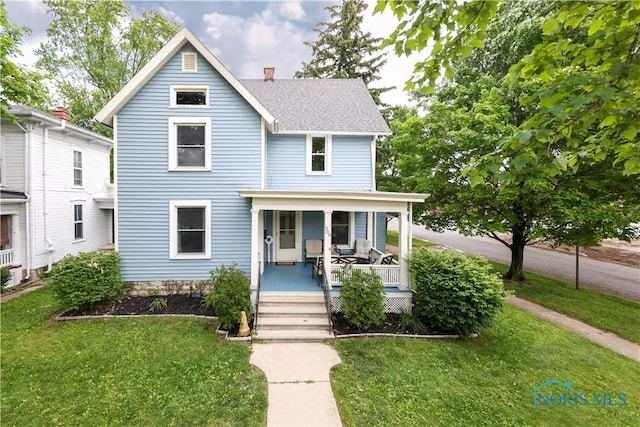 view of front of home featuring covered porch and a front lawn