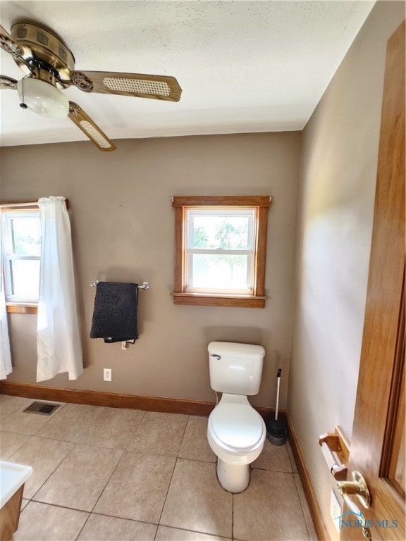 bathroom with tile floors, ceiling fan, and toilet