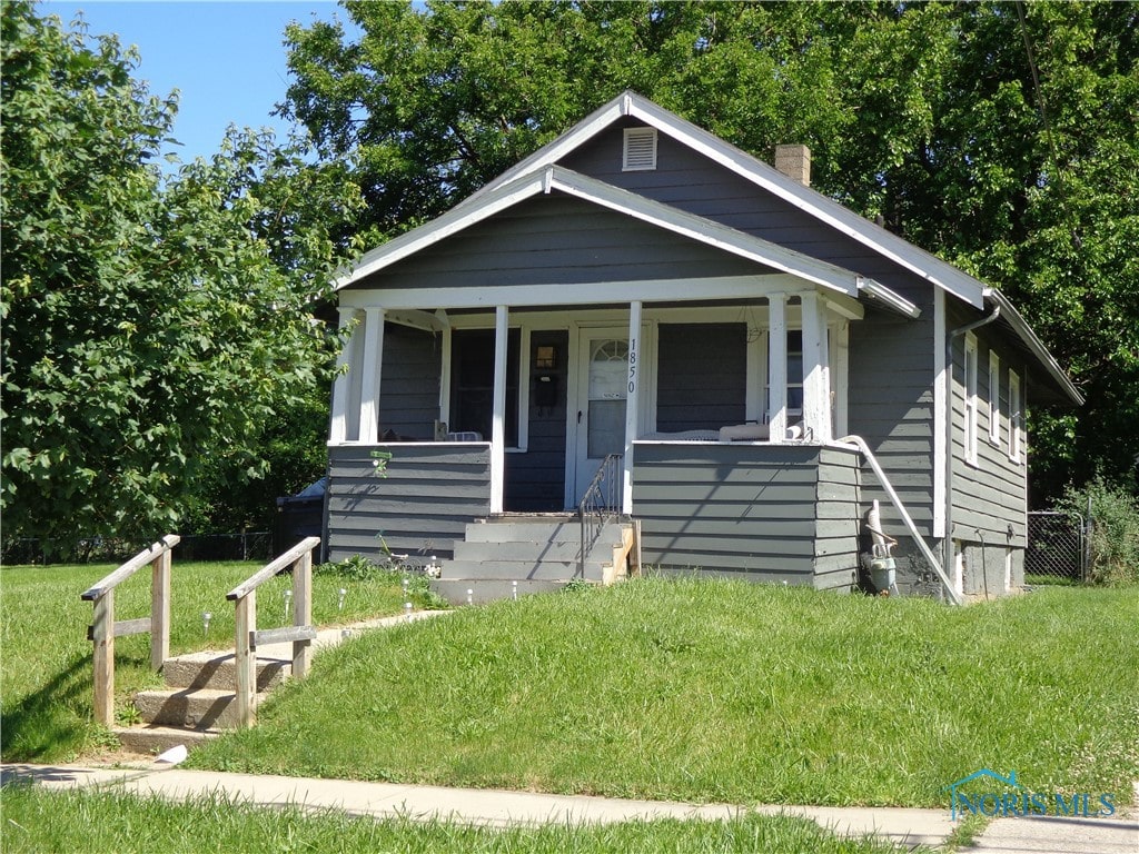 bungalow-style house with covered porch and a front lawn