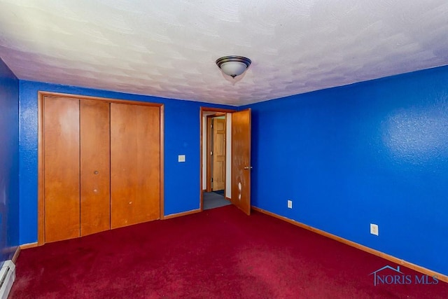 unfurnished bedroom featuring a closet, a baseboard radiator, and dark carpet