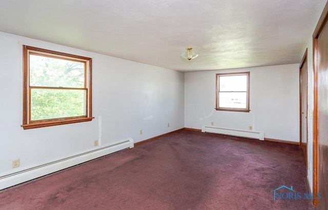 empty room featuring dark colored carpet and a baseboard heating unit