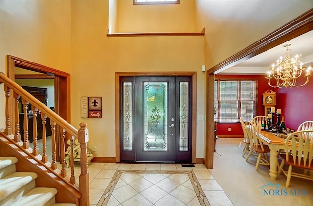 tiled entrance foyer featuring an inviting chandelier