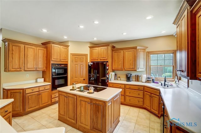 kitchen with light tile patterned flooring, a kitchen island, sink, and black appliances