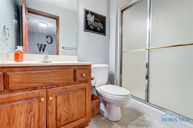 bathroom with tile patterned floors, walk in shower, vanity, and toilet