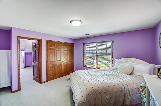 bedroom featuring light carpet and a closet