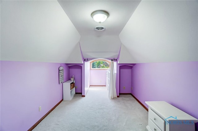 additional living space featuring lofted ceiling and light carpet