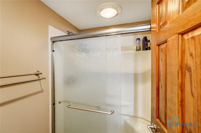 bathroom with bath / shower combo with glass door