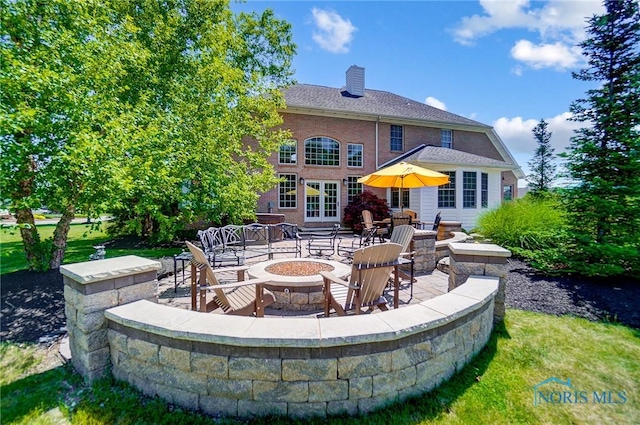 exterior space with an outdoor fire pit and french doors