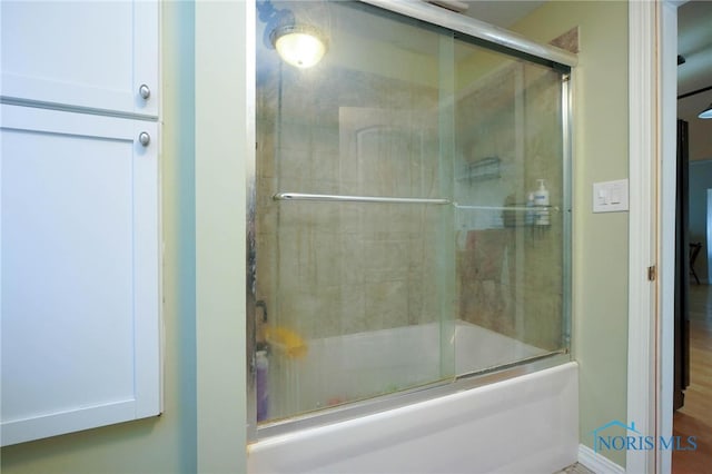 bathroom with combined bath / shower with glass door