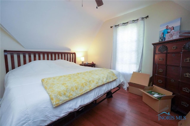 bedroom featuring dark hardwood / wood-style floors, ceiling fan, multiple windows, and vaulted ceiling